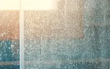 Hard water mineral spotting on shower glass